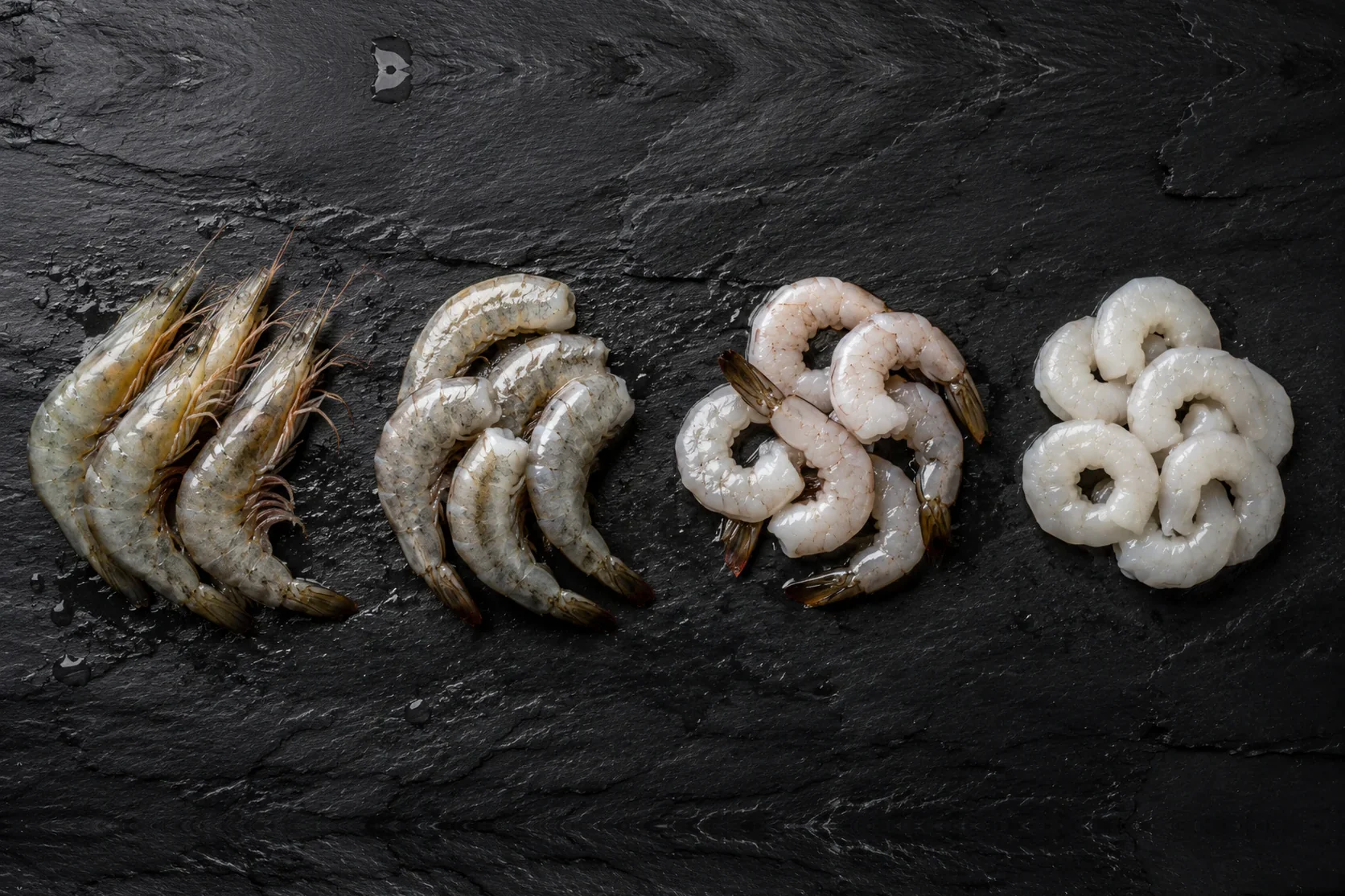 Fresh prawns in four stages — whole, headless, peeled and deveined